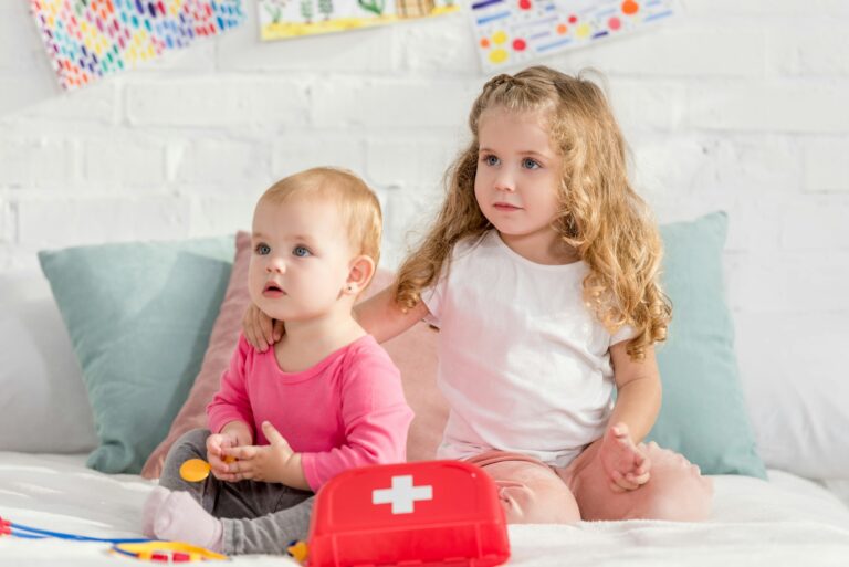 adorable sisters playing with first aid kit in children room and looking away