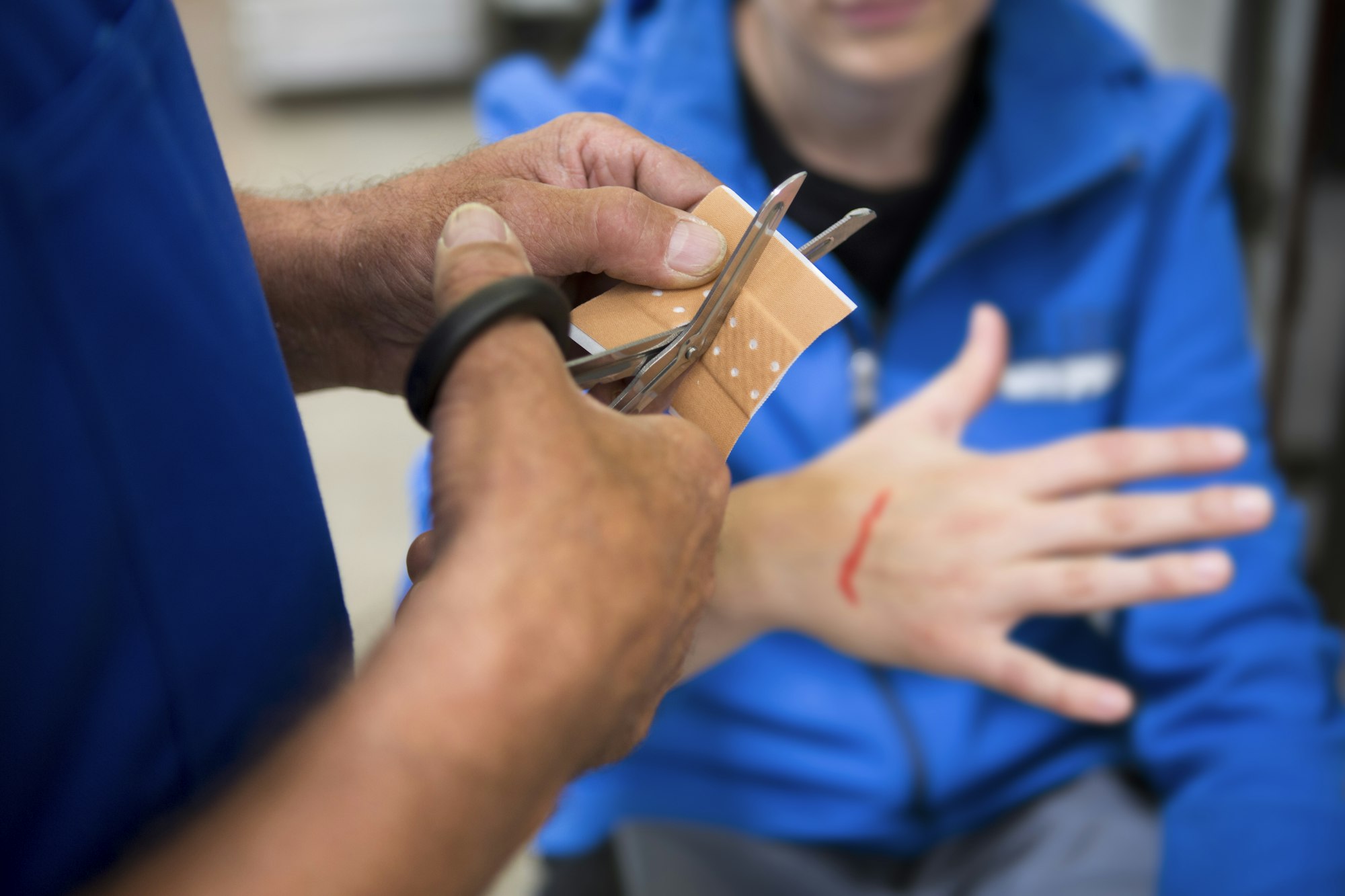 Factory worker applying first aid to colleague